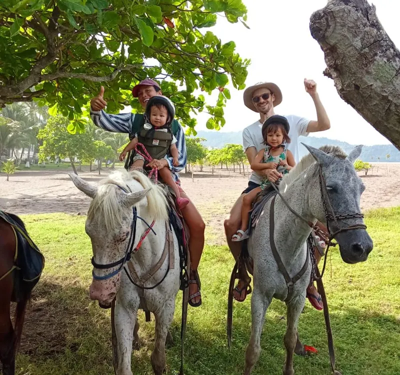 Riders horseback riding through tropical Costa Rican landscape near the Pacific